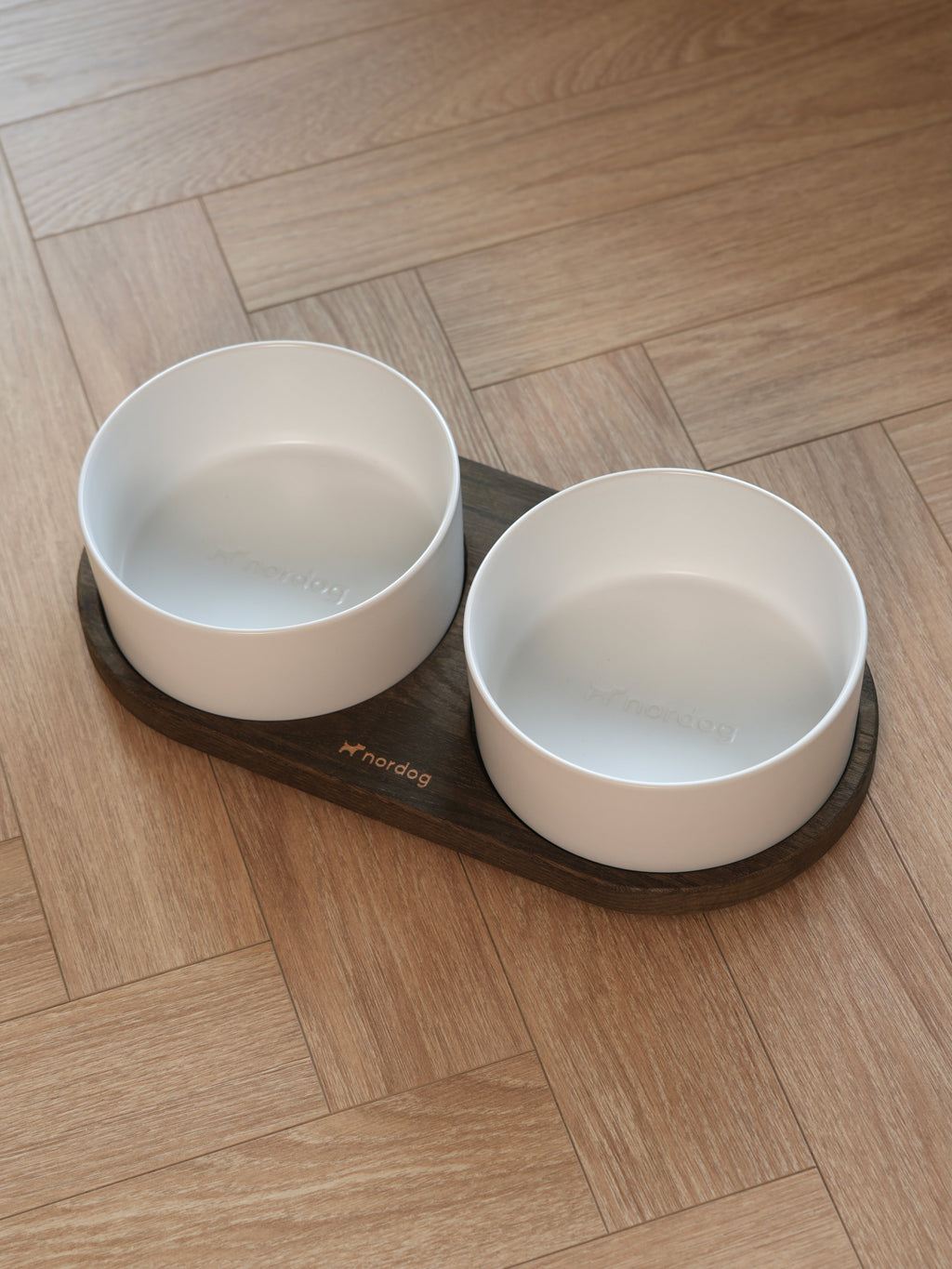 Nordog Barcelona — smoked oak with white ceramic bowls in use