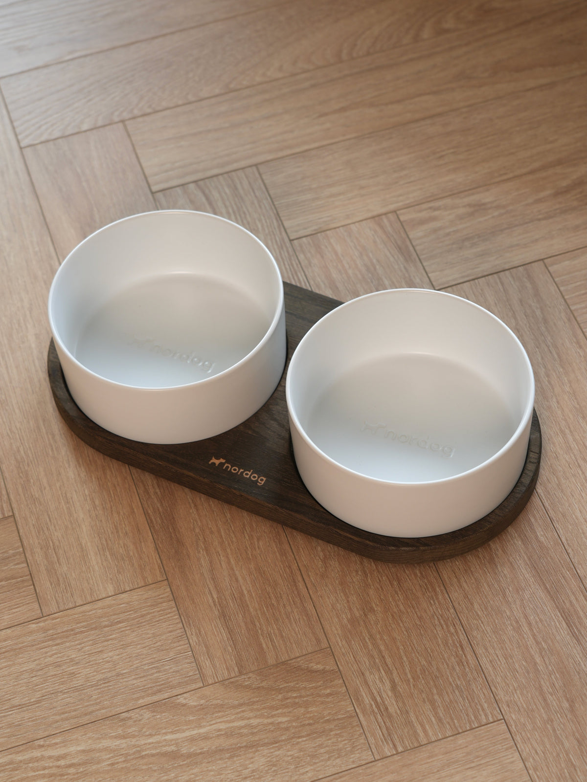 Nordog Barcelona — smoked oak with white ceramic bowls in use